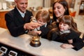 Fully enjoy your stay. Happy family checking in hotel at reception desk. A son and a daughter are ringing a service bell Royalty Free Stock Photo