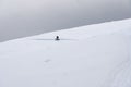 Fully-equipped cyclist riding a bicycle in snowy mountains Royalty Free Stock Photo