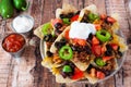 Fully loaded Mexican nacho chips on rustic wood background Royalty Free Stock Photo