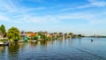 Fully operational historic Dutch Windmills and houses along the Zaan River Royalty Free Stock Photo