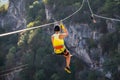 Fun, adrenaline and adventure on the zip line. Teenager having fun on a zipline on panoramic forest background. Zipline in the for Royalty Free Stock Photo