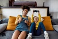 Fun. African american woman, baby sitter and caucasian cute little girl having fun together, playing video games Royalty Free Stock Photo