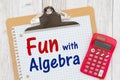 Fun with Algebra message on graph paper with a clipboard with calculator