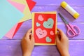 Child is holding a Valentines day card in his hands. Small child made a Valentines day greeting card. Cute and simple paper crafts Royalty Free Stock Photo