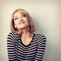 Fun beautiful thinking blond young woman in sweater looking up