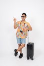 A fun, cheerful Asian man tourist is pointing his finger up at an empty space, isolated background Royalty Free Stock Photo