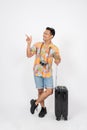 A fun, cheerful Asian man tourist is pointing his finger up at an empty space, isolated background Royalty Free Stock Photo