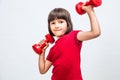 Fun child enjoying raising hands with dumbbells expressing proud success