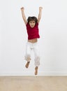 Fun child jumping and raising arms high to express happiness Royalty Free Stock Photo