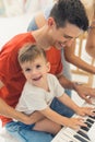 Fun childhood concept. Music in the life of young children. Happy smiling proud caucasian dark-haired dad playing the Royalty Free Stock Photo