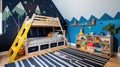 A fun children's room with a blue accent wall, a wooden loft bed with a ladder Royalty Free Stock Photo