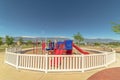 Fun colorful childrens playground overlooking lake snowy mountain and blue sky