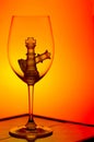 Chess king and queen in a wine glass against gradient background Royalty Free Stock Photo