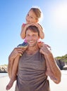 Fun with dad. Portrait of a handsome man giving his cute daughter a piggyback ride at the beach. Royalty Free Stock Photo