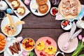 Fun Easter breakfast or brunch frame. Above view on a dark wood background. Royalty Free Stock Photo