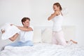 Fun, energy and couple fighting with pillows on the bed in hotel room on a romantic weekend trip. Happy, love and young
