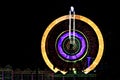 Fun fair Giant Ferris wheel spinning at night. Slow shutter photograph of a rotating giant wheel at night. Royalty Free Stock Photo