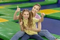 Fun family activities. Mother and daughter showing thumbs up gesture at indoor trampoline park Royalty Free Stock Photo