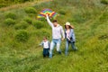 Fun family pastimes. Young parents with their kid flying kite together on green meadow Royalty Free Stock Photo