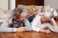 Fun on the floor with granny and gramps. A little boy lying on top of his grandparents on the floor of their living room Royalty Free Stock Photo