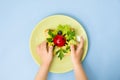 Fun food art for kids. Children`s hands hold plate with ladybug sandwich on blue background. How to make creative Royalty Free Stock Photo