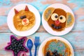 Fun food for children. Cat and dog shaped pancakes on white plates, blue wooden background, top view. Creative idea for kids Royalty Free Stock Photo