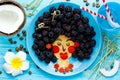 Fun food idea for kids - edible hawaiian girl face from pancake and blackberry, food art Royalty Free Stock Photo