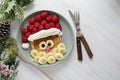 Fun food for kids. Christmas Santa pancake with raspberry and banana for children menu, top view with copy space