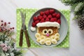Fun food for kids. Christmas Santa pancake with raspberry and banana for children menu, top view with copy space