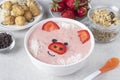 Fun food for kids - smoothie-bowl in shape funny piglet, with strawberries, granola, chocolate and crispy balls on gray