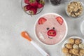 Fun food for kids - smoothie-bowl in shape funny piglet, with strawberries, granola, chocolate and crispy balls, Top