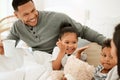 Fun for four. a beautiful young family talking and bonding in bed together. Royalty Free Stock Photo