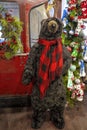 Fun large furry Bear in store greeting customers wearing Red Plaid Scarf