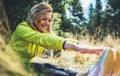 Fun girl exercising outdoors in green park, activity with stretch legs. Smile fitness woman stretching exercises training outside Royalty Free Stock Photo