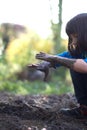 Fun grounded child playing in garden, observing mud on hands Royalty Free Stock Photo