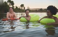 Fun group of diverse friends relaxing in lake water, enjoying nature and bonding on a getaway vacation in the Royalty Free Stock Photo