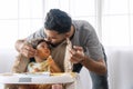 Fun handsome single father feeding spaghetti for his mixed race daughter while baby girl sitting on high chair. Infant cute