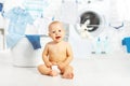 Fun happy baby boy to wash clothes and laughs in laundry Royalty Free Stock Photo