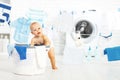 Fun happy baby boy to wash clothes and laughs in laundry Royalty Free Stock Photo