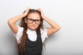 Fun happy pupil kid girl in eyeglasses scratching the head two h