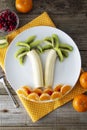 Fun and healthy fruit salad for kids, kiwi banana mandarin palm trees. Healthy food for children Royalty Free Stock Photo