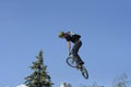 Fun jumping. Young boy, the cycler, soaring high in the blue sky with the bike Royalty Free Stock Photo