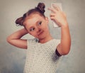 Fun kid girl posing and making a selfie photo on mobile phone. V Royalty Free Stock Photo