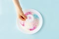 Fun kids science experiments. Step by step instruction: how to make colorful stains in milk. Step3 kids hand add cotton pad with