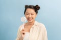 Fun lifestyle. Playful lady smiling holding lollipop on blue background