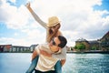 Fun loving young couple frolicking at a waterfront