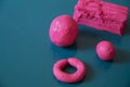 Fun plasticine texture painted on a modeling board. Toying with pink plasticine. Consists of the plasticine. Modeling figure. Lett