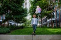 Fun portrait of happy energetic mature businessman holding balloons and walking on wall , feeling free, work life Royalty Free Stock Photo