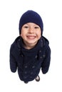 Fun portrait of smiling boy wit hat and winter coat, isolated. High angle perspective Royalty Free Stock Photo