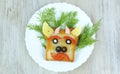 Fun sandwich with slice meat sausage, cheese, bell pepper, olives, dill on plate . funny baby food in the form of an animal face. Royalty Free Stock Photo